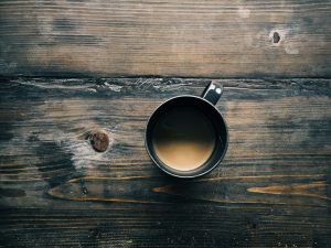 Cup of coffee on a dark wooden desk