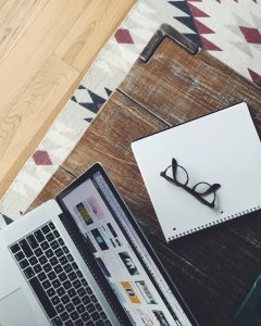 Over top view of desk with laptop and notepad